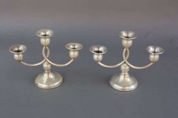 Two 7409, pair of silver candelabras with three holders and curved arms, on a gray background.