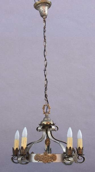 Vintage 9679. Spanish Revival Chandelier with Pewter & Gold-tone Details with five candle-like bulbs mounted on an ornate brass frame, suspended by a long, twisted chain against a gray background.