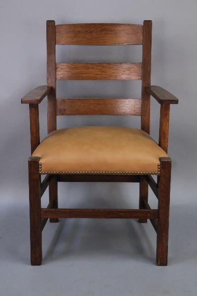 A 10215. Handsome Turn Of The Century Oak Arts And Crafts Chair with three horizontal back slats and a cushioned seat covered in light tan upholstery, set against a neutral background.