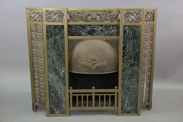Antique 10317. Early 1900's Fireplace Surround with ornate gold detailing and a central panel featuring an embossed classical design on a metal medallion, flanked by green marble-like sections.