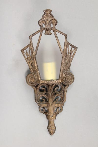 Ornate gold wall sconce with frosted glass.