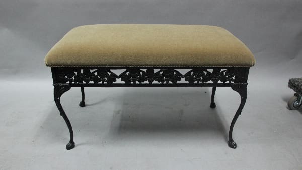 Iron bench with padded seating surface.