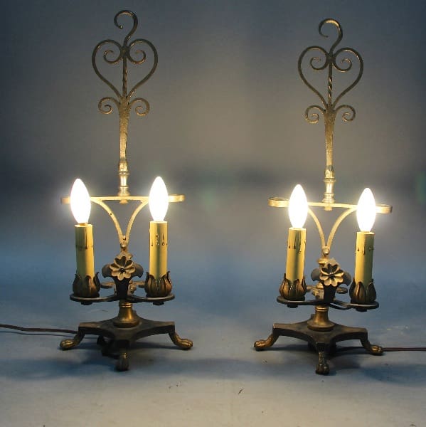 A pair of 12373. Pair Of 1920's Spanish Revival Table Lamps with three lit bulbs each, set against a soft blue gradient background.