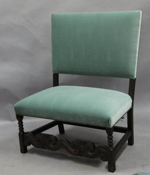 Green upholstered chair with wooden legs.