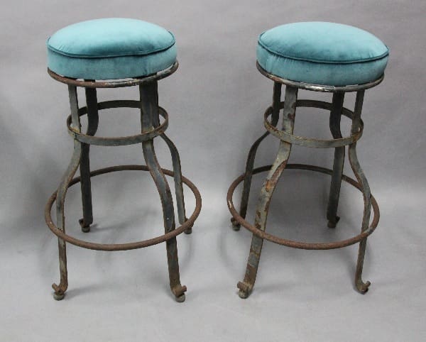 Two vintage bar stools with turquoise cushions.