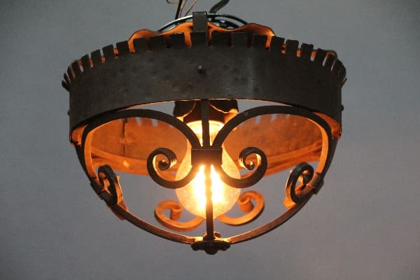 Ornate metal ceiling light with bulb.