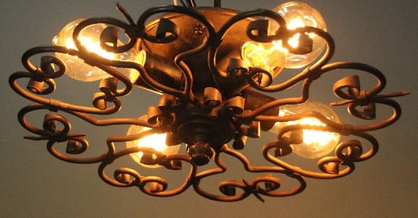 Ornate metal chandelier with light bulbs.