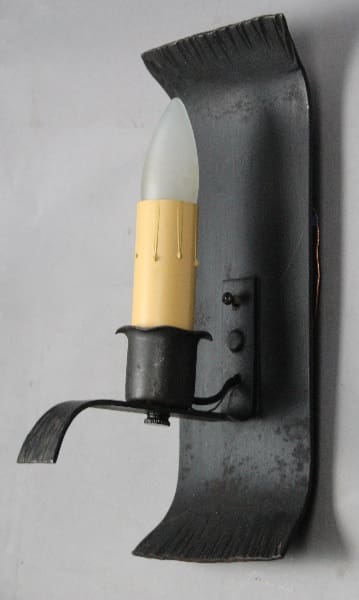 Wall-mounted candle-style light fixture.
