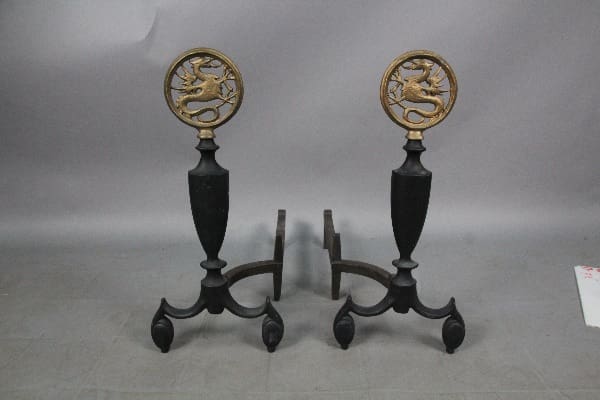 Two 12866. Pair Of 1920's Andirons With Beautiful Dragons with ornate tops featuring a lion design, set against a gray background.