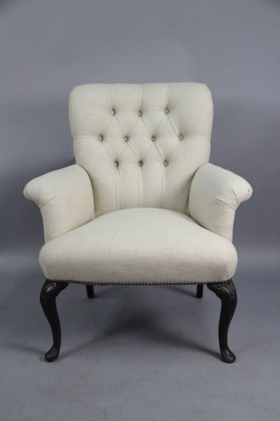 Elegant tufted armchair with dark wooden legs.