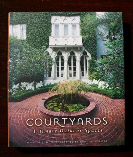 A book titled "1305. Courtyards Intimate Outdoor Space" by douglas keister, featuring a cover image of a lush courtyard with a central circular pond and surrounded by dense greenery.