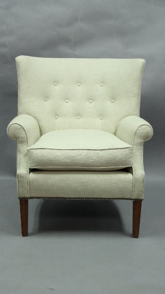 Elegant cream-colored upholstered armchair.