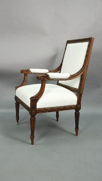 Elegant wooden armchair with white upholstery.