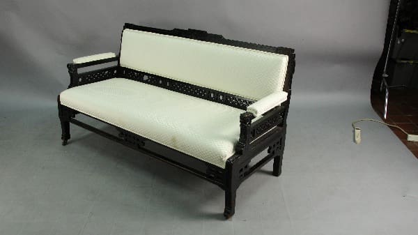Black wooden sofa with white upholstery.