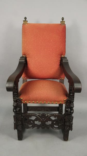 Ornate wooden chair with orange upholstery.