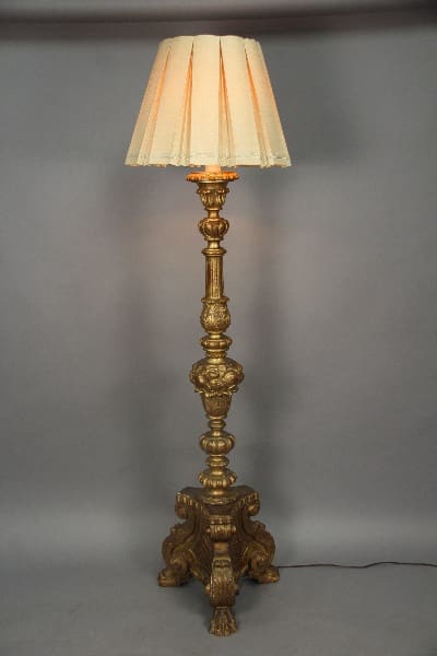 Ornate gold floor lamp with fabric shade.
