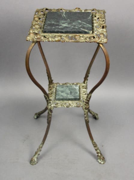 Turn Of The Century Side Table With Shelf plant stand with curved legs and square marble tops, on a gray background.