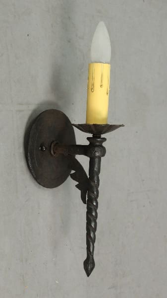 Wall-mounted candle holder with yellow candle.