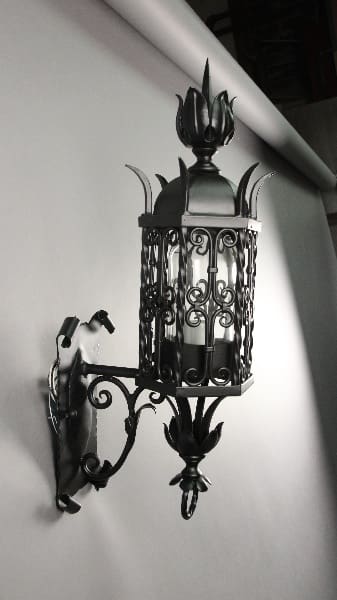 Ornate black wall lantern with floral design.