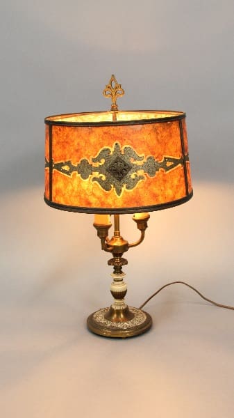 13717. 1920's Table Lamp With Beautiful Period Mica Shade with a stained glass shade featuring ornate patterns and a decorative metal cross on top, illuminated against a neutral background.