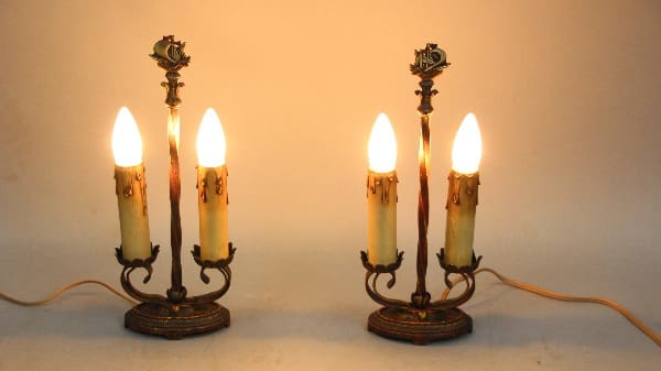 Two 13757 pairs of 1920's table lamps with Galleon design and lit bulbs, against a warm beige background.