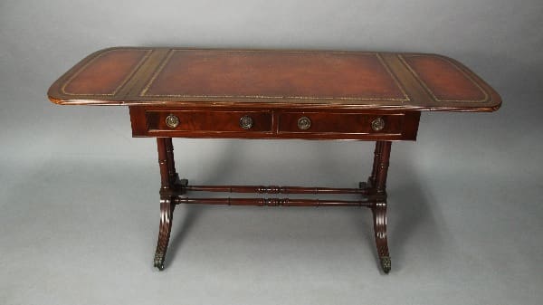 Antique wooden writing desk with 13808. Leather Top Desk With Side Panels, featuring three drawers and ornate legs, displayed against a neutral backdrop.
