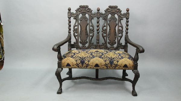 Ornate two-seater patterned upholstered bench.