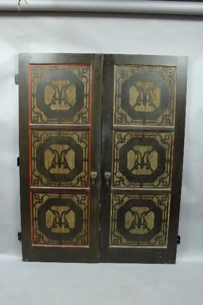 Pair of original 1920's carved doors with original polychrome finish, displayed against a grey backdrop.