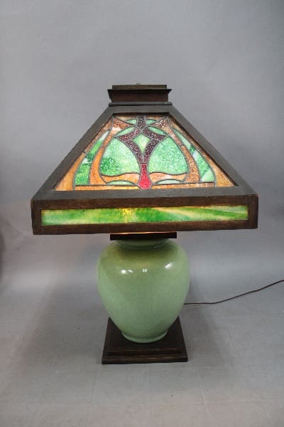 A 14015 large scale Arts and Crafts table lamp with great wood and a stained glass shade in green and purple colors.