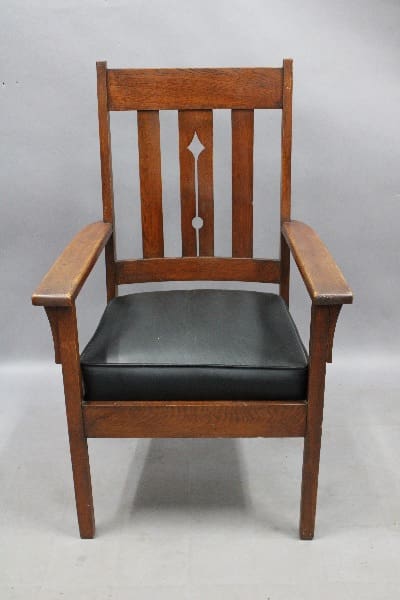 Vintage 14039. Arts And Crafts armchair with a black leather seat, featuring a tall, straight backrest with a decorative cut-out design.