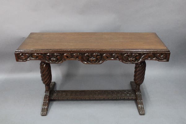 An 14045. Spanish Revival Console Table with a twisted rope design on the legs and intricate floral patterns along the edges, set against a plain grey backdrop.
