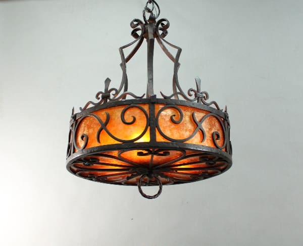 Wrought iron chandelier with orange glass shade.