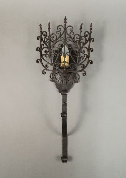 Ornate wall sconce with candle holder.