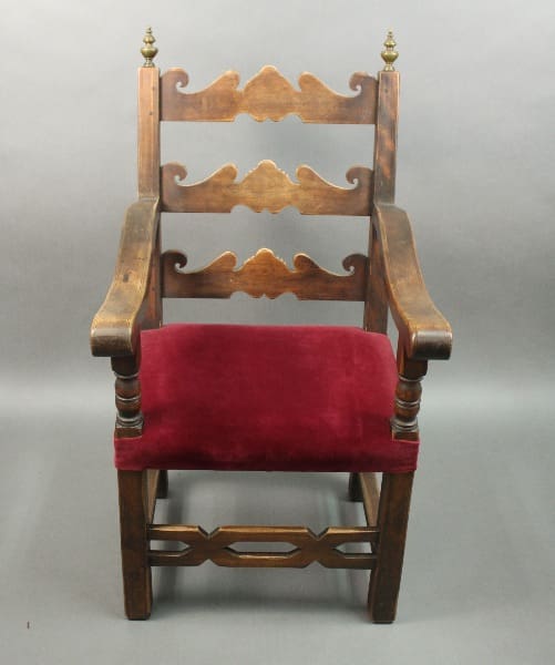 Wooden chair with red upholstered seat.