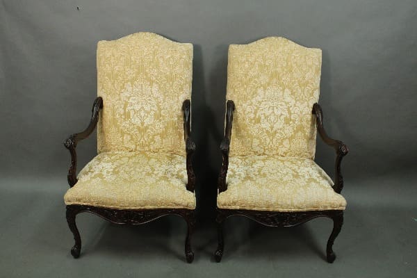 Antique upholstered chairs with wooden frames.