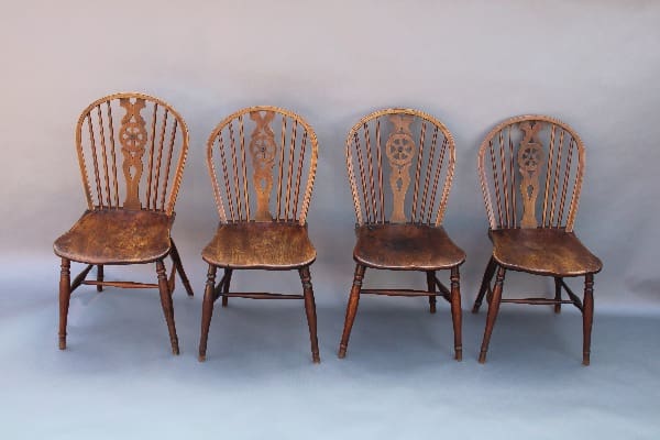 Four vintage wooden chairs in a row.