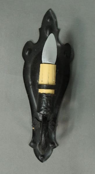 Wall-mounted light fixture with decorative backing.