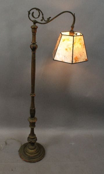 14866. Spanish Revival floor lamp with a lit, stained glass shade and ornate metal stand, set against a gray background.