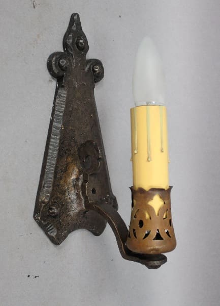 Wall-mounted candle-shaped light fixture.