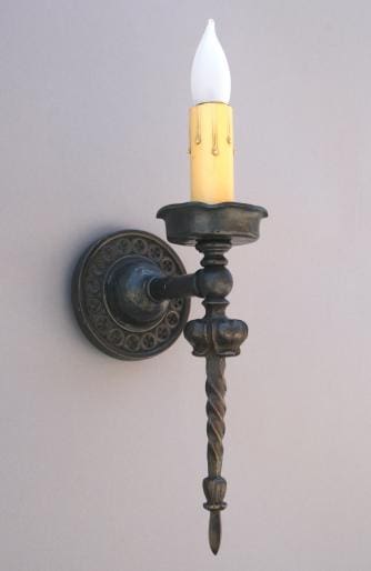 Black wall sconce with candle-like bulb.