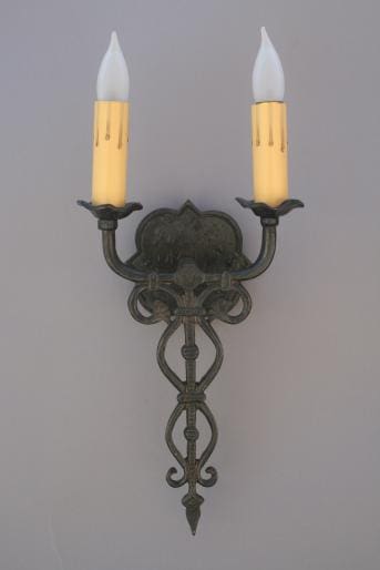 Wall-mounted candle holder with two candles.