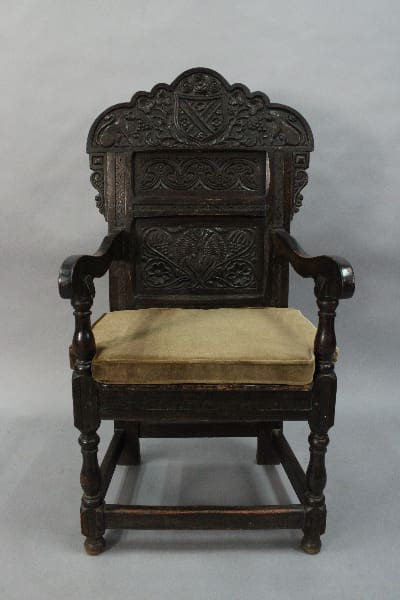 Ornately carved wooden chair with cushioned seat.