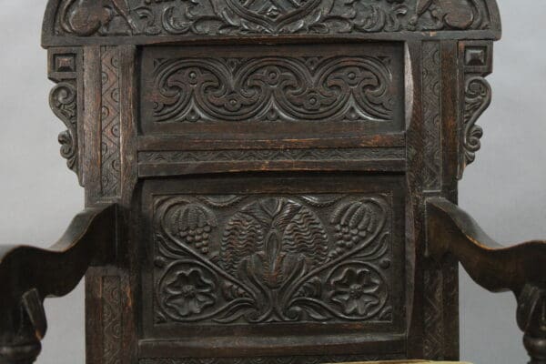 Intricately carved wooden chair backrest design.
