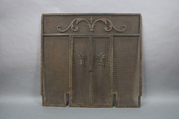 15002. Turn Of The Century Large Scale Fire Screen with decorative metal scrollwork and vertical slats, set against a plain backdrop.