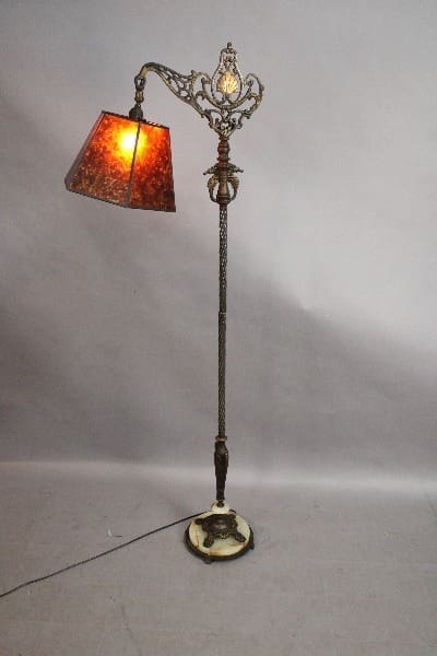 15099. 1920's Bridge Lamp With New Mica Shade with ornate metal stand and a glowing amber lampshade, set against a plain light grey background.