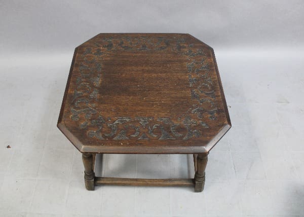 An 15114. Spanish Revival Side Table With Etched Top with ornate carvings on its surface and legs, against a plain background.
