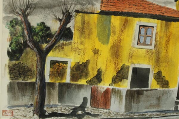 Yellow house with tree and cloudy sky.