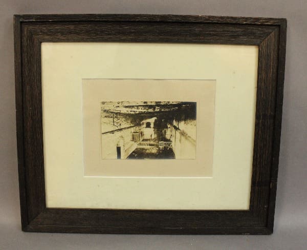 Framed historical photograph of a dark interior.