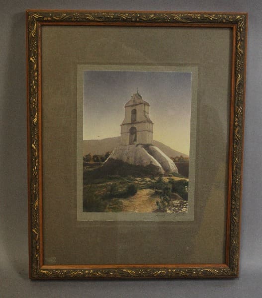 Framed painting of a tower on a hill.