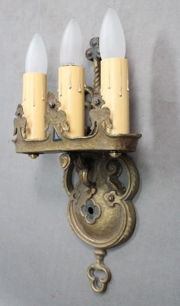 Vintage brass wall sconce with three lights.